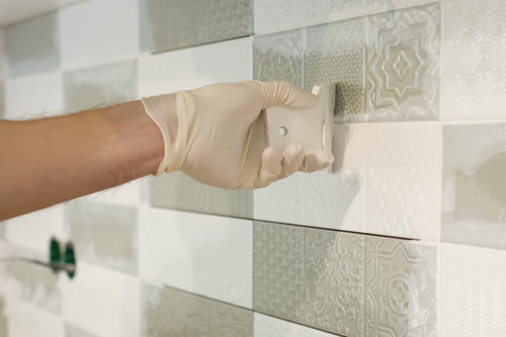 Everything Covering Tile with Epoxy Closeup of tiler hand rubbing tile, Installing and grouting decorative finishes in environments with an high aesthetic value. Two-component, decorative, acid resistant epoxy grout.
Covering Tile with Epoxy