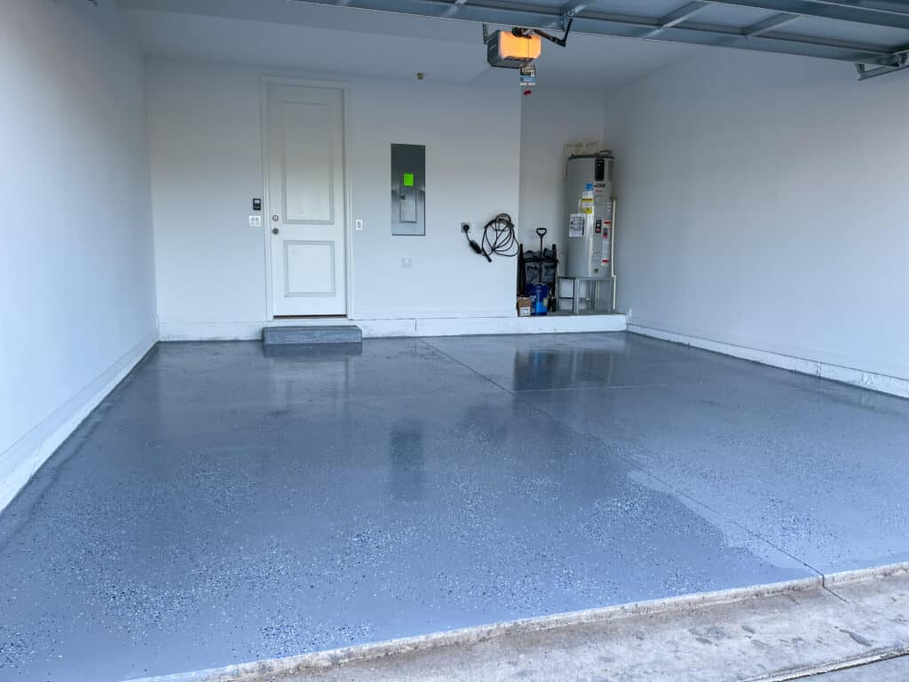 Is There a Better Time of Year to Install A Garage Floor Coating? A freshly painted with a gray epoxy finish sprinkled with blue, black and white plastic chips. Install A Garage Floor