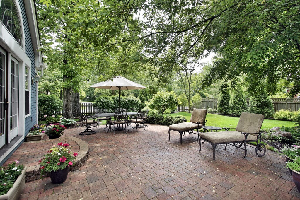 7 Ways to Spruce Up Your Patio in Summer Brick patio with table umbrella and chairs. Your Patio in Summer